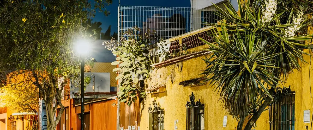 Street in the town of de Allende, Mexico, with a yellow building on the side of it